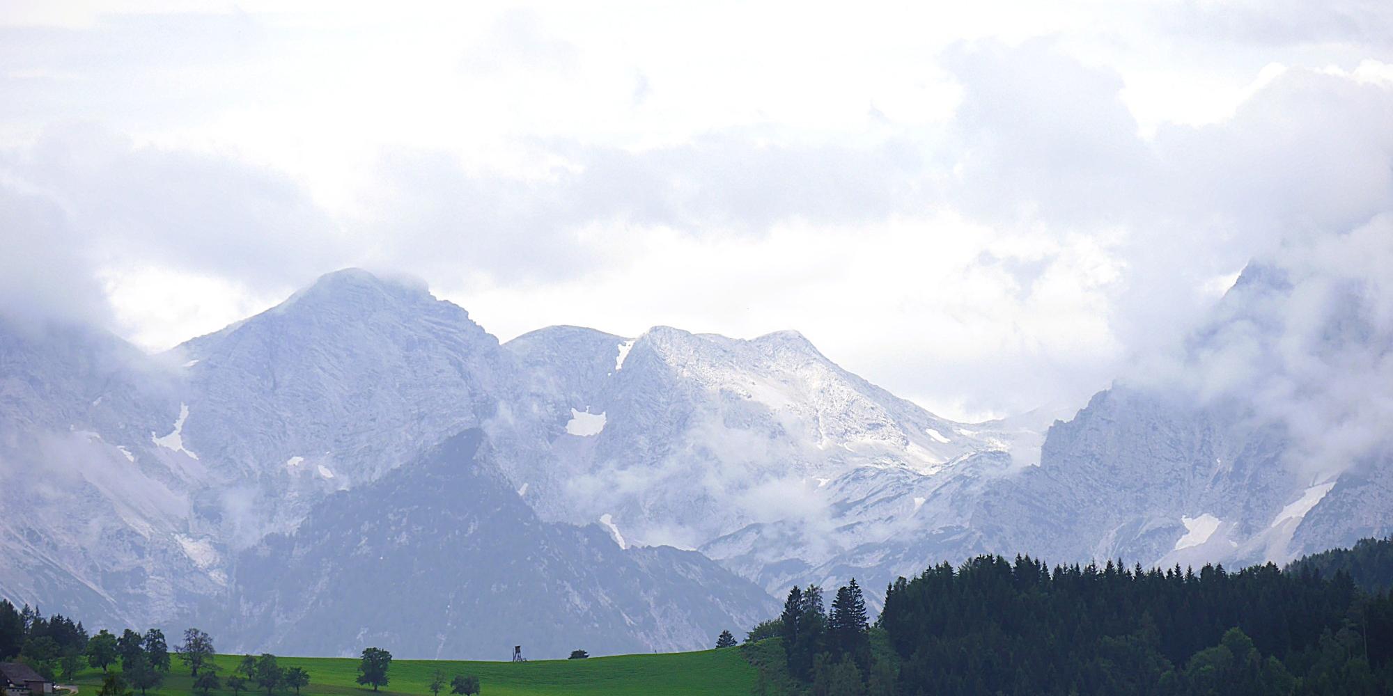 Das Bild zeigt eine Berglandschaft mit grünen Hügeln im Vordergrund und Felsmassiv im Hintergrund. (c) Martina Wagner Das Bild zeigt eine Berglandschaft mit grünen Hügeln im Vordergrund und Felsmassiv im Hintergrund.