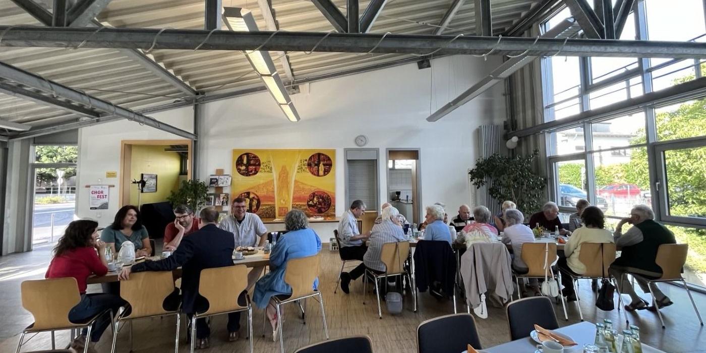 Mitglieder der Kolpingsfamilie Gladbach sitzen im Pfarrheim an Tischen.