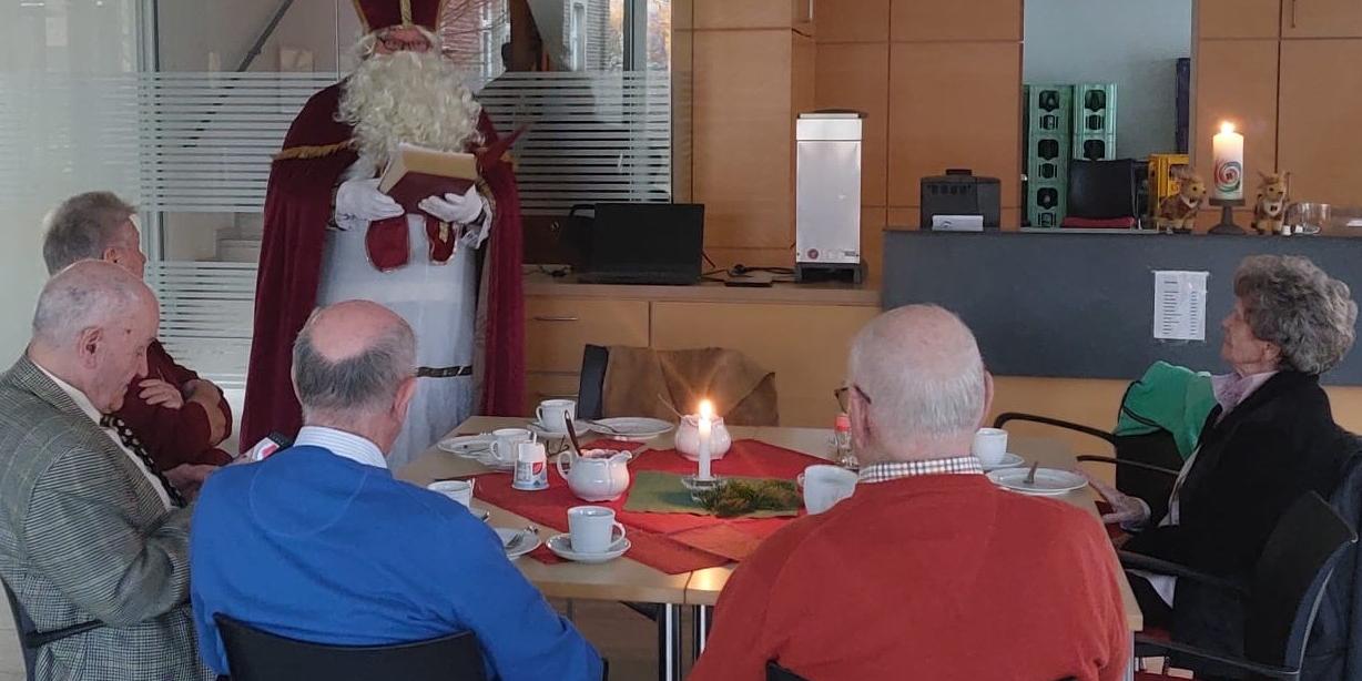 Menschen sitzen am Tisch und hören dem Nikolaus zu (c) Kolpingsfamilie Sinzig Menschen sitzen am Tisch und hören dem Nikolaus zu