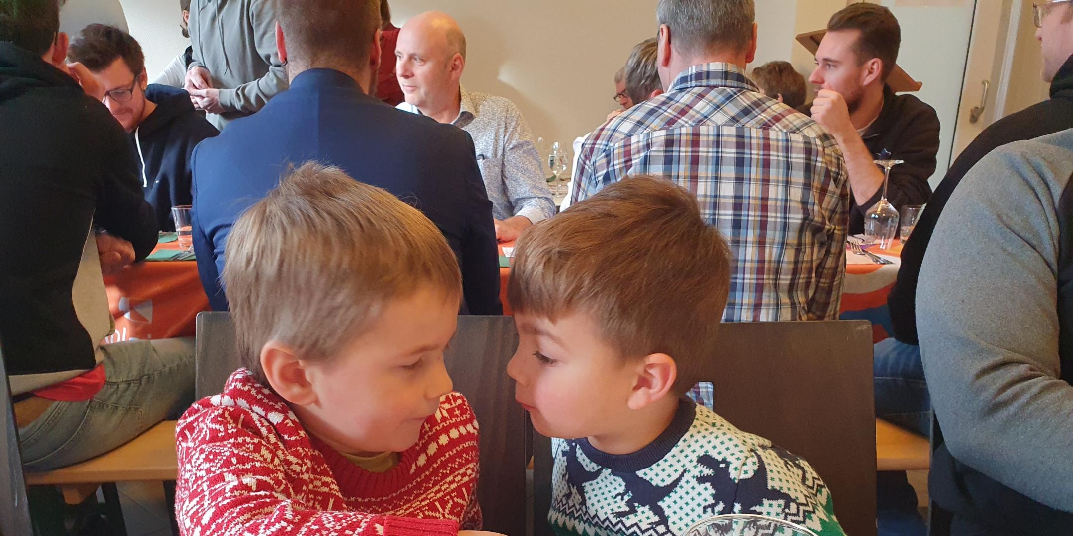 im Vordergrund zwei Kinder in Weihnachtspullis, im Hintergrund Menschen im Gespräch (c) Kolpingsfamilie Dernau im Vordergrund zwei Kinder in Weihnachtspullis, im Hintergrund Menschen im Gespräch