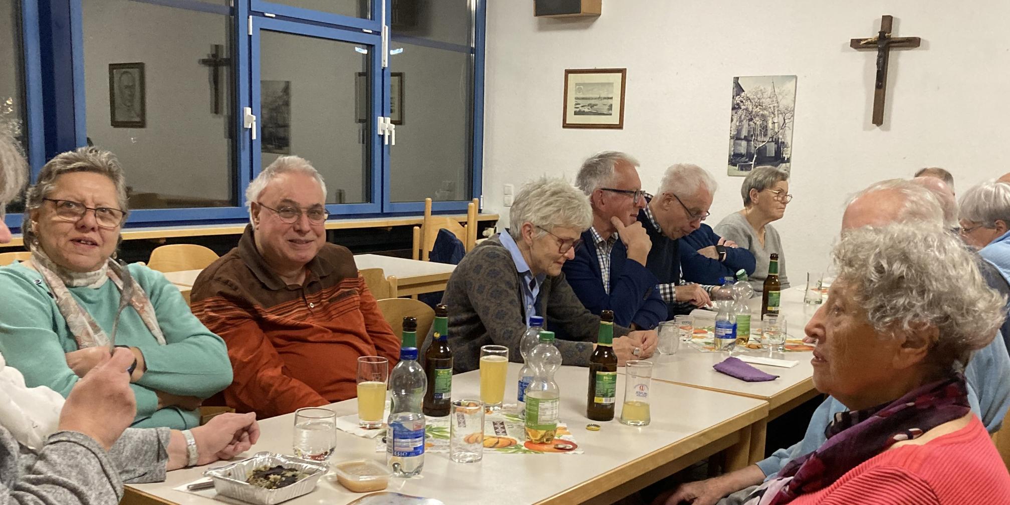 Menschen sitzen am Tisch und unterhalten sich