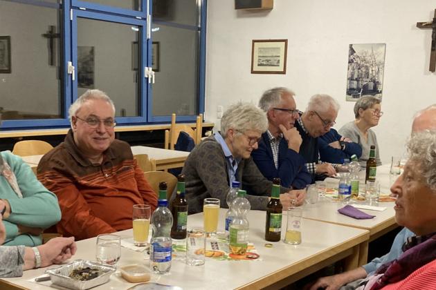 Menschen sitzen am Tisch und unterhalten sich