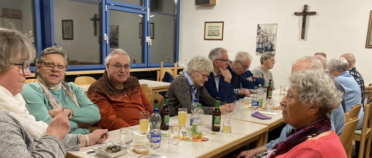 Menschen sitzen am Tisch und unterhalten sich