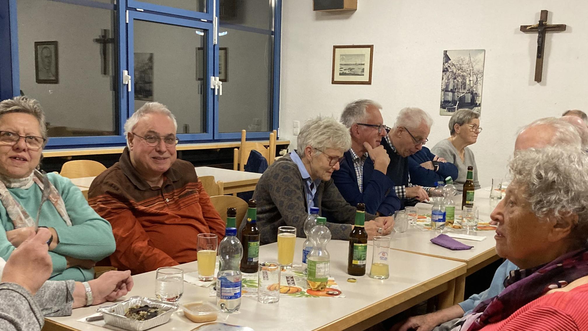 Menschen sitzen am Tisch und unterhalten sich