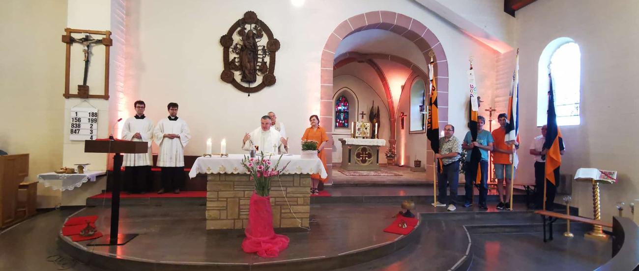 Altarraum der Kirche St. Quiriakus in Mechern mit Geistlichen, Messdienenden und Bannerträgern mit Kolpingbannern