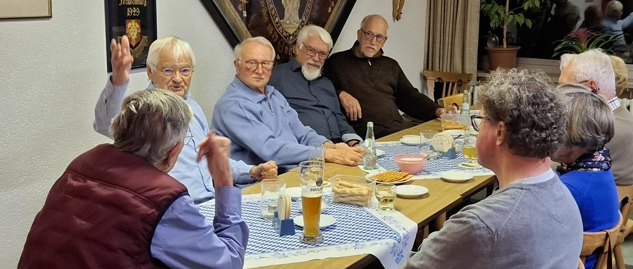 Mitglieder der Kolpingsfamilien sitzen zum gemütlichen Beisammensein am Tisch