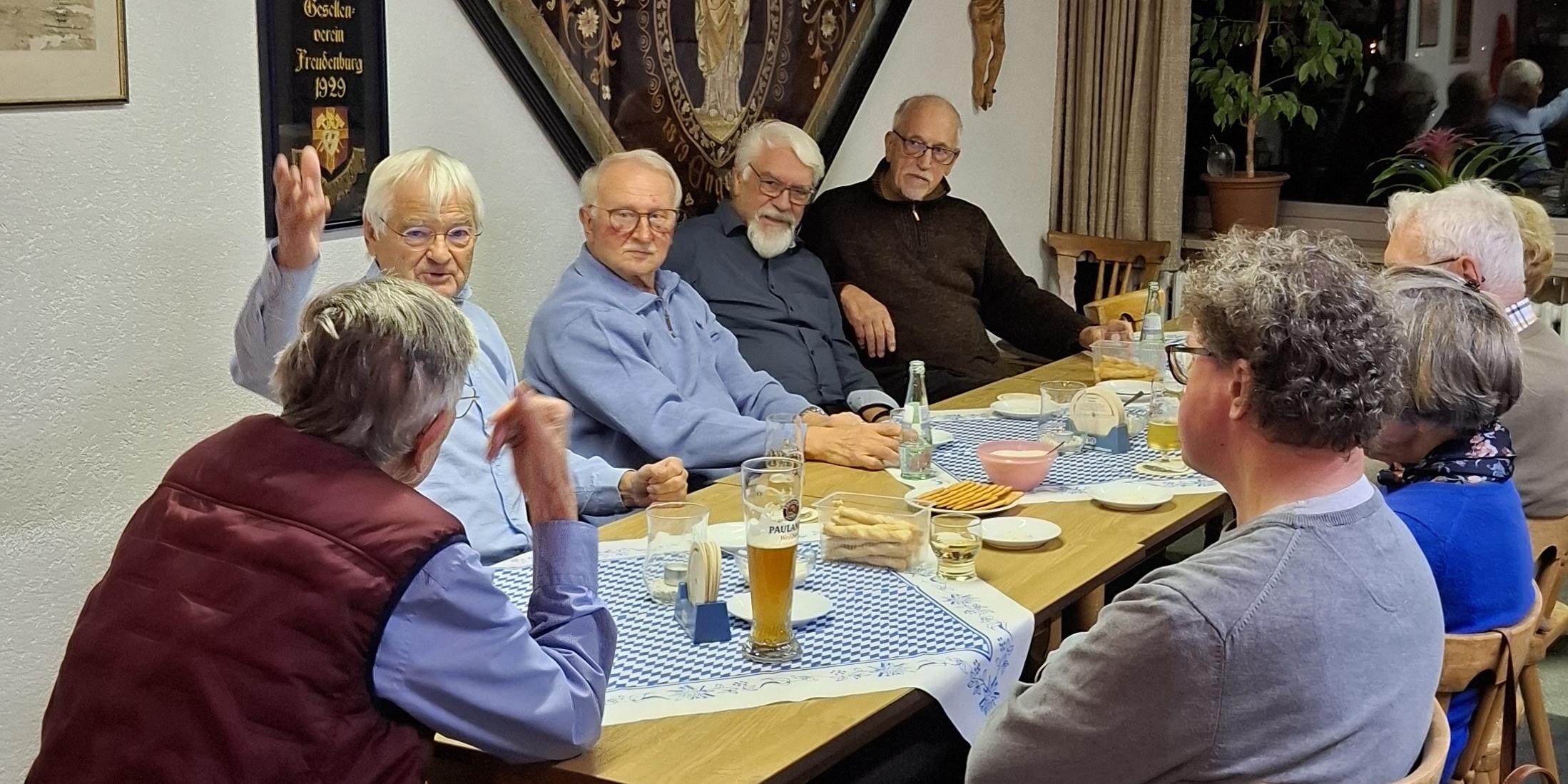 Mitglieder der Kolpingsfamilien sitzen zum gemütlichen Beisammensein am Tisch