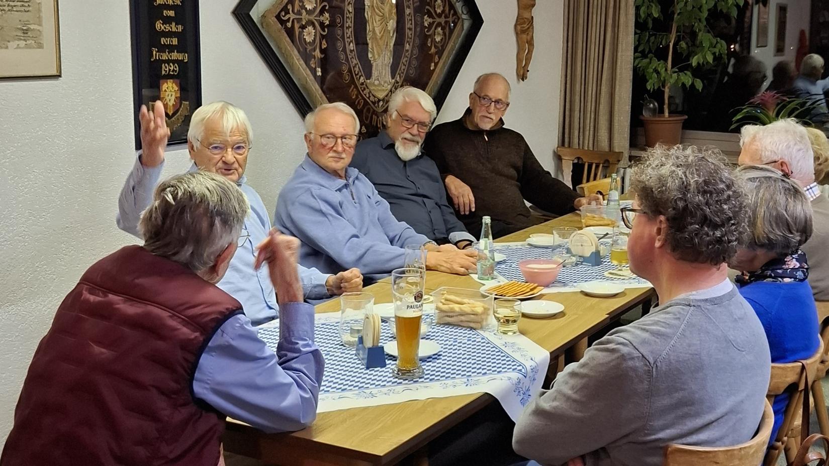 Mitglieder der Kolpingsfamilien sitzen zum gemütlichen Beisammensein am Tisch