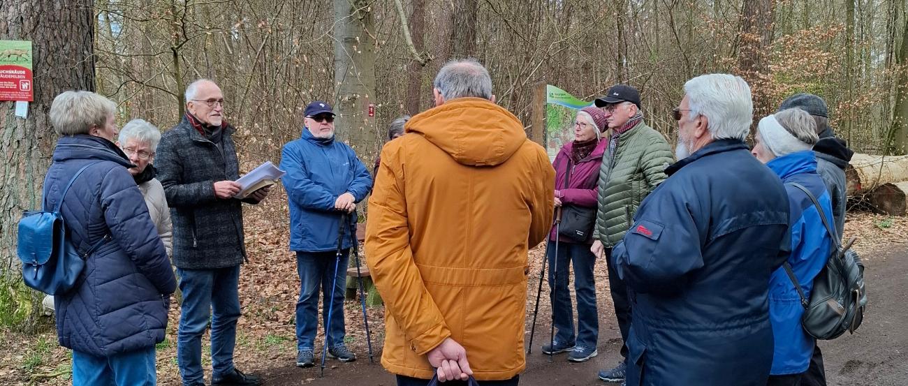 Mitglieder der Kolpingsfamilie Engers hören im Wald einen geistlichen Impuls