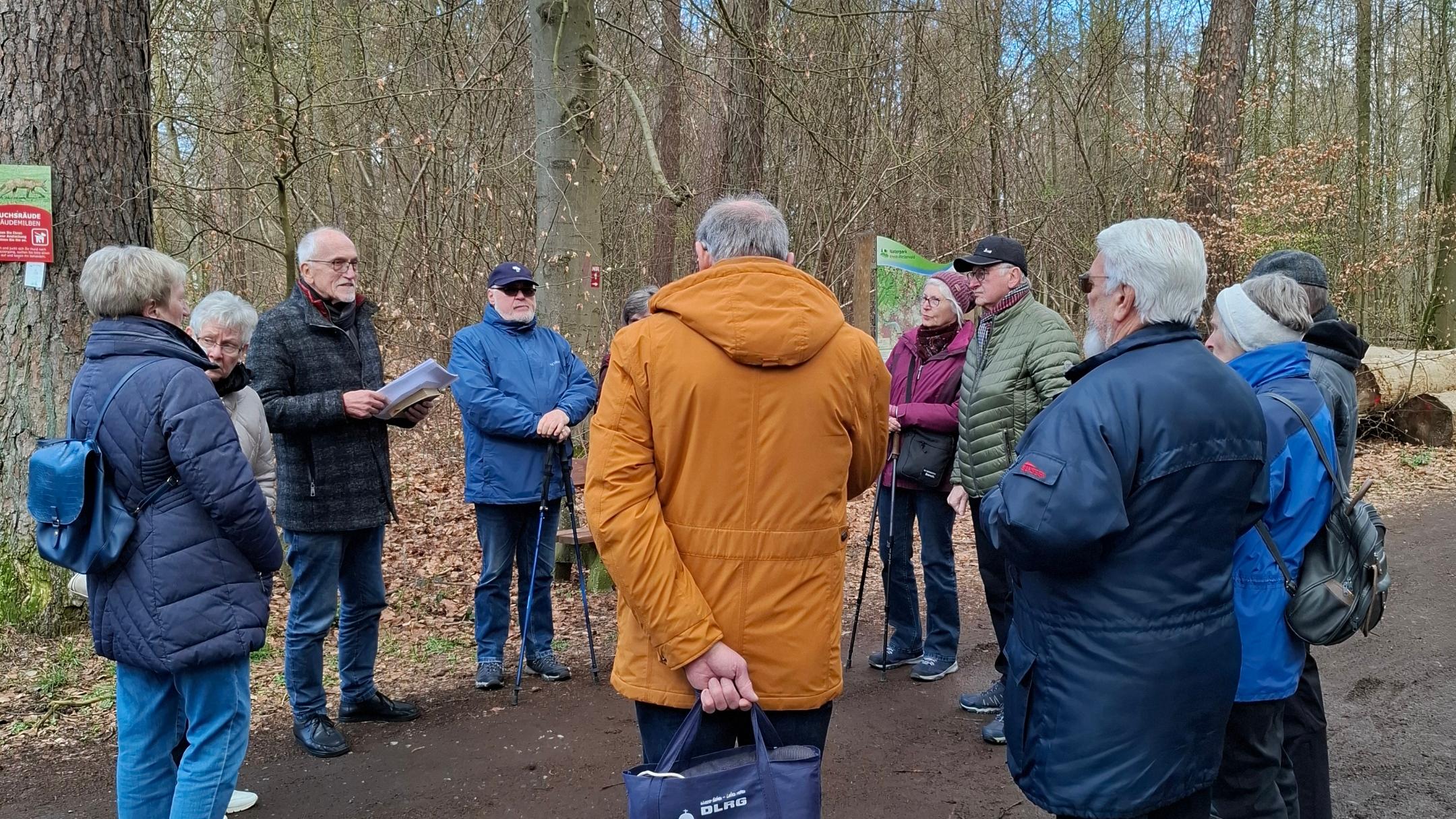 Mitglieder der Kolpingsfamilie Engers hören im Wald einen geistlichen Impuls