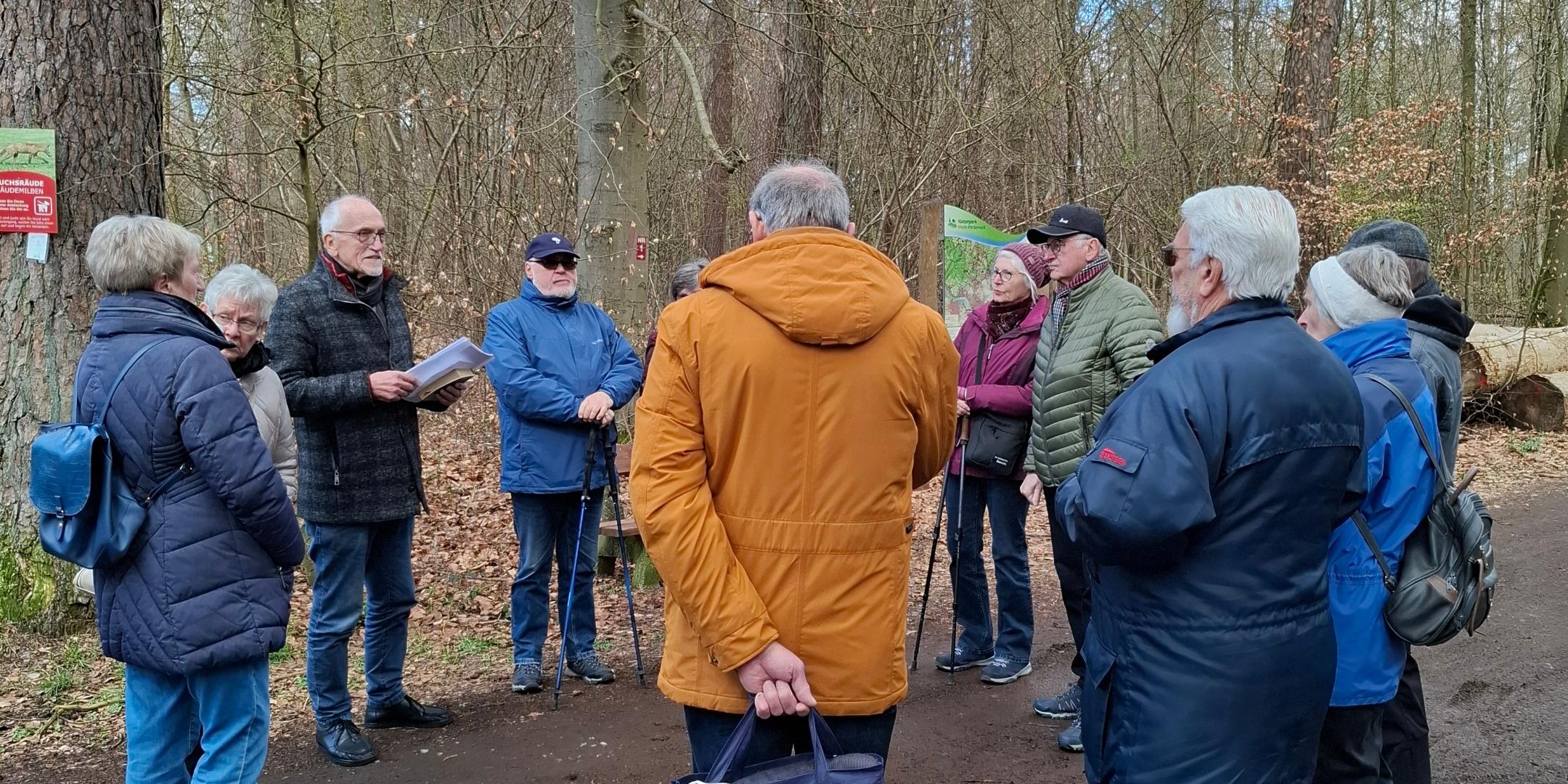 Mitglieder der Kolpingsfamilie Engers hören im Wald einen geistlichen Impuls