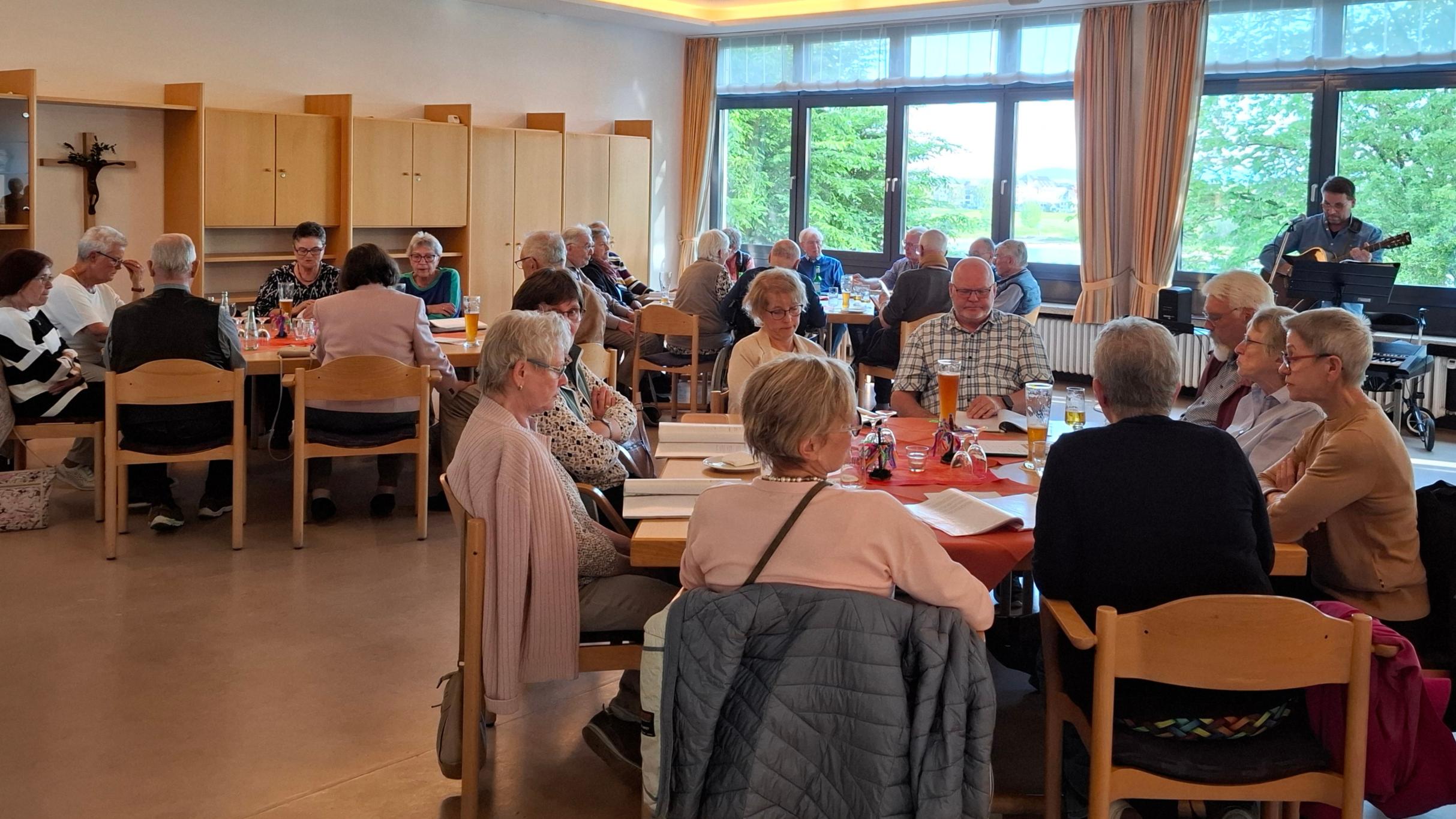 Mitglieder der Kolpingsfamilie Engers singen, im Hintergrund Gitarrenspieler