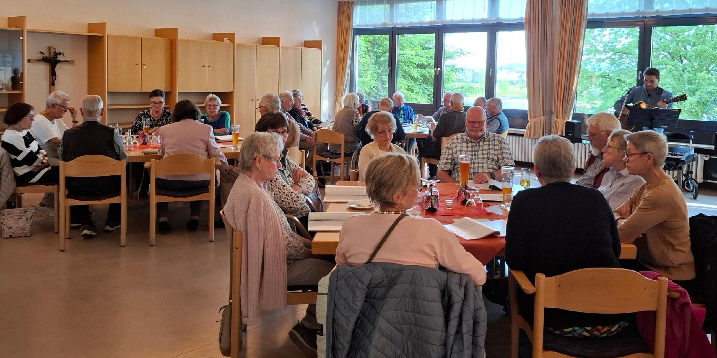 Mitglieder der Kolpingsfamilie Engers singen, im Hintergrund Gitarrenspieler