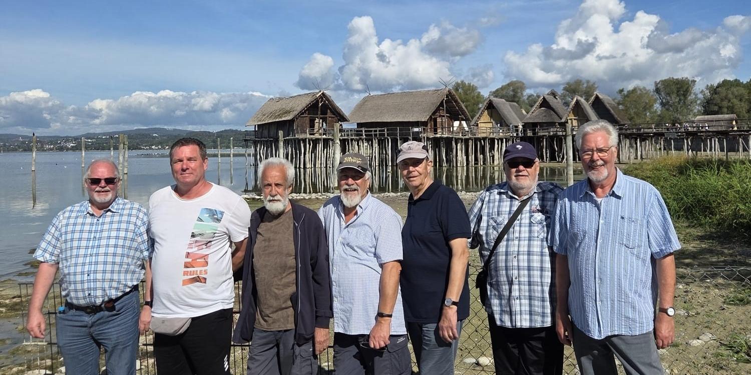 Am Ufer des Bodensees (c) Walter Jung Kegeltruppe Engers - 7 Männer stehen nebeneinander vor Häusern auf Stelzen am Bodensee