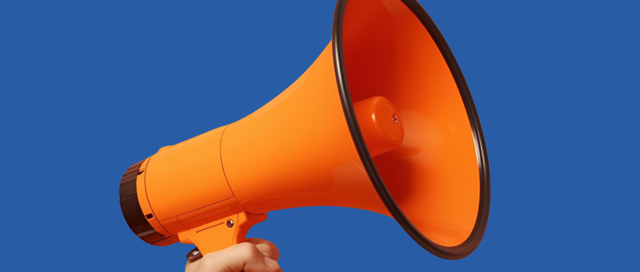 Hand, die ein oranges Megaphon hält vor dunkelblauem Hintergrund