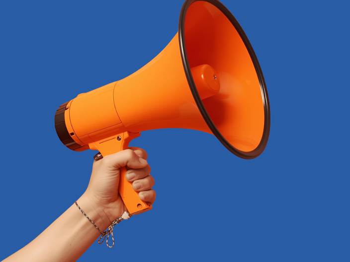 Hand, die ein oranges Megaphon hält vor dunkelblauem Hintergrund