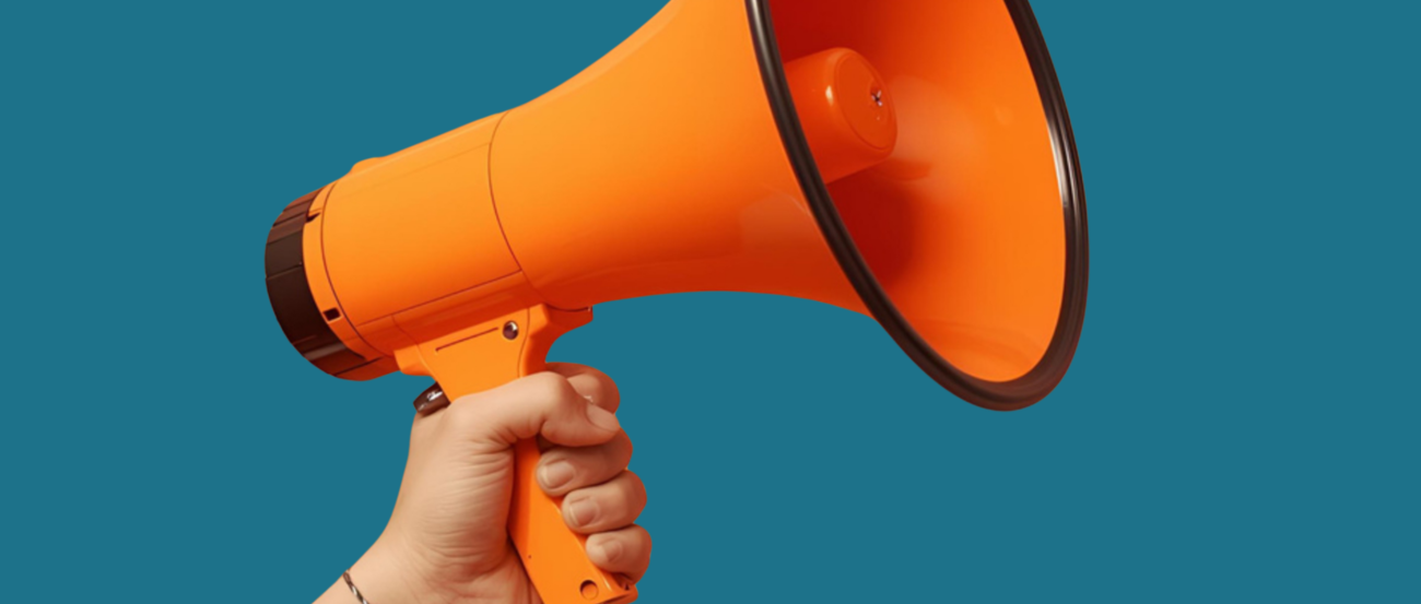 Hand, die ein oranges Megaphon hält vor smaragdgrünem Hintergrund