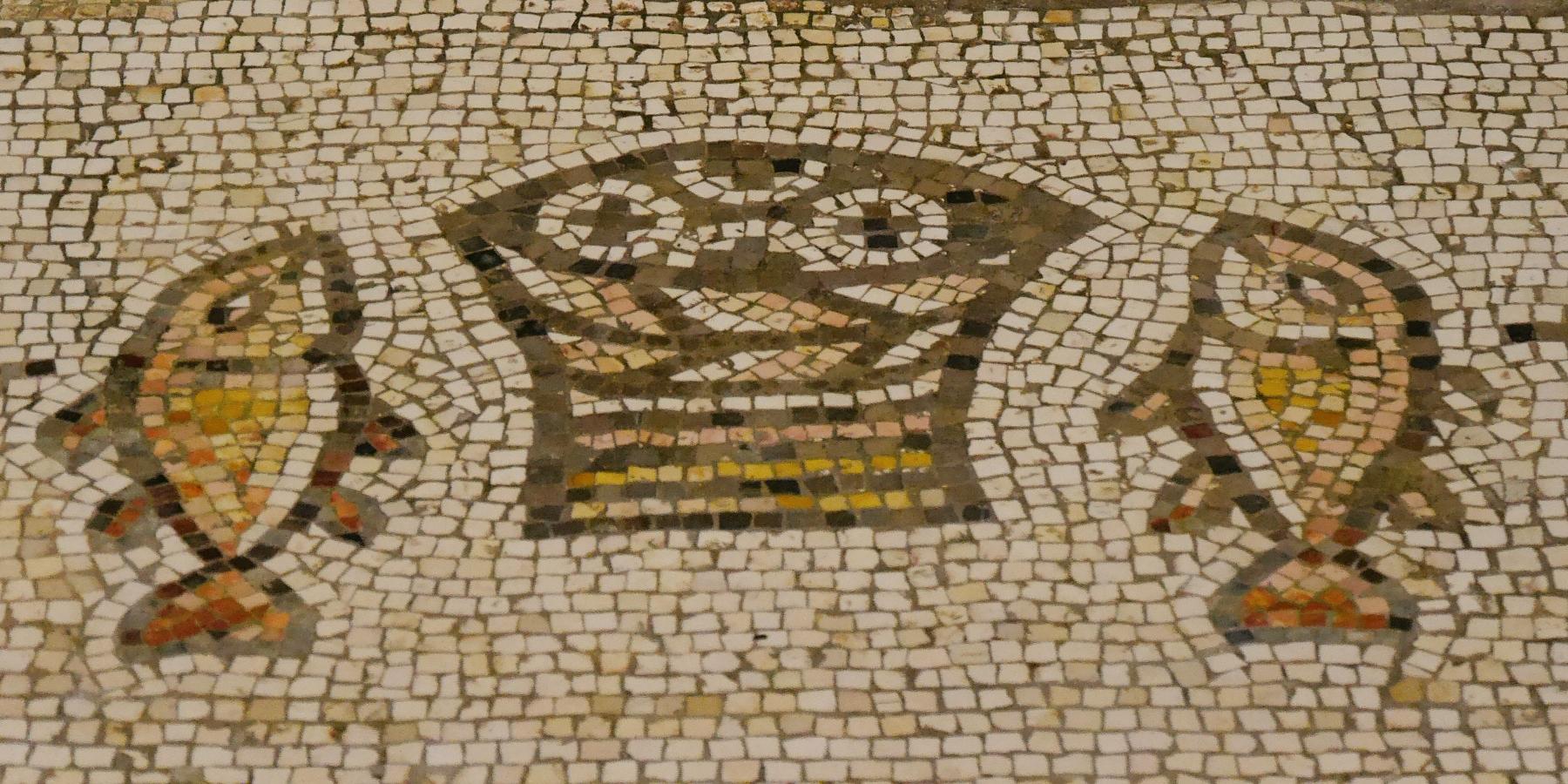 Steinmosaik in Beige- und Brauntönen, das einen Korb mit Broten in der Mitte und an jeder Seite einen Fisch zeigt. (c) Martina Wagner Steinmosaik in Beige- und Brauntönen, das einen Korb mit Broten in der Mitte und an jeder Seite einen Fisch zeigt.