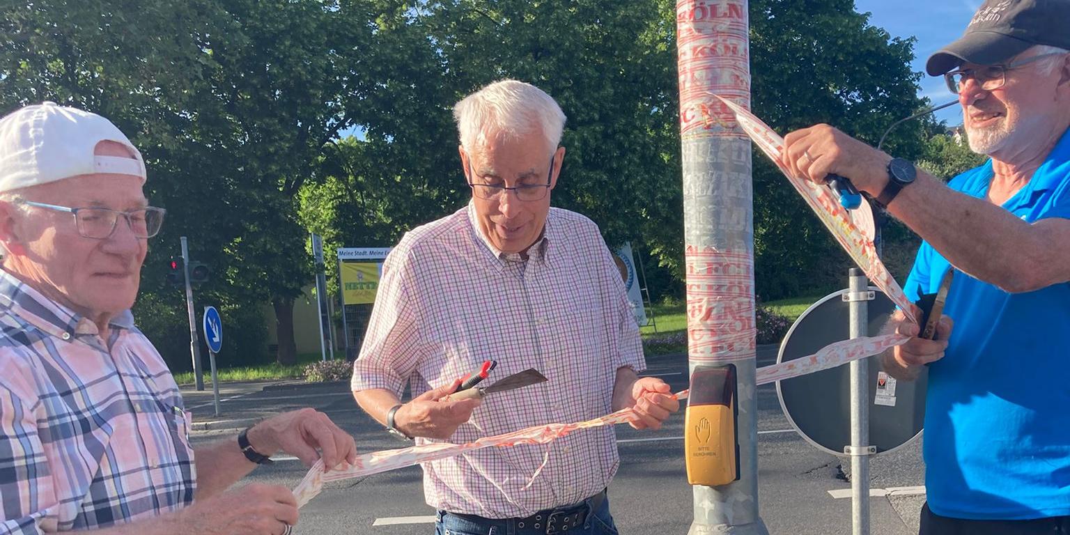 Drei Mitglieder der Kolpingsfamilie Neuwied entfernen Aufkleber von einem Verkehrsstraßenschild (c) Werner Hammes Drei Mitglieder der Kolpingsfamilie Neuwied entfernen Aufkleber von einem Verkehrsstraßenschild