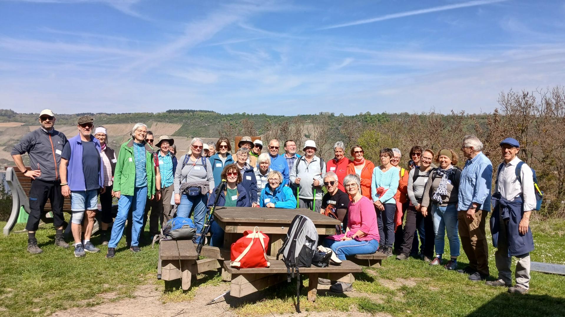 30-köpfige Pilgergruppe vor einer Bank mit strahlend blauem Himmel