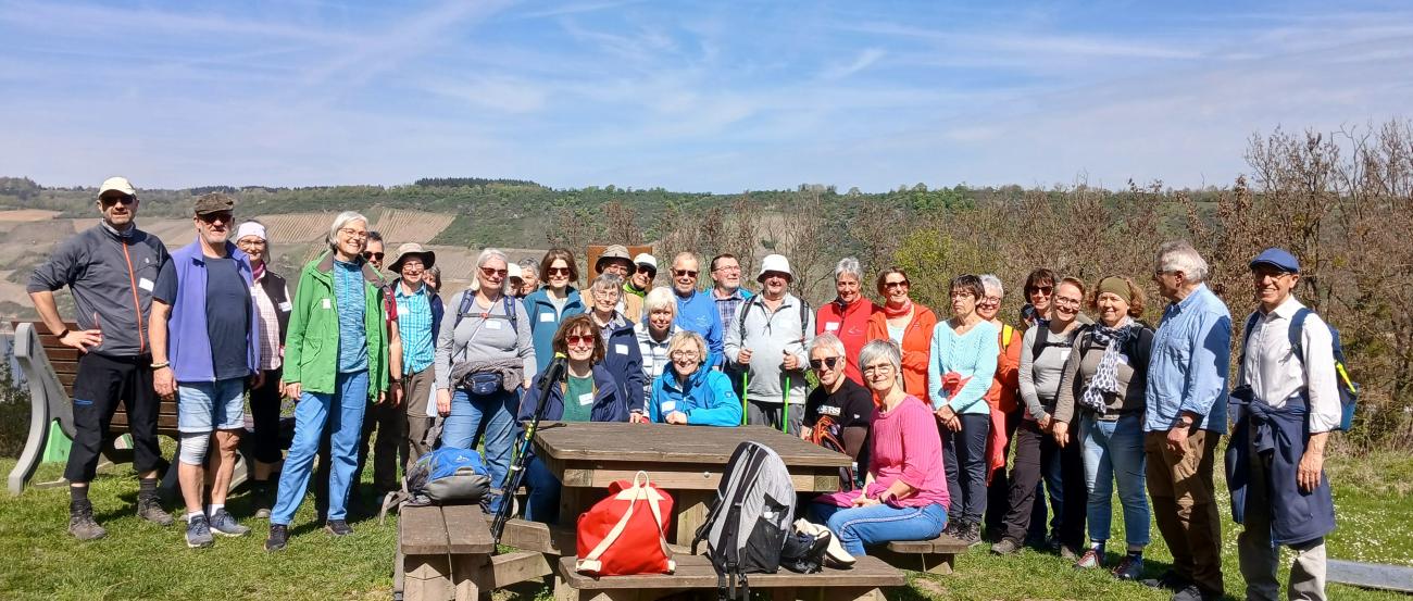 30-köpfige Pilgergruppe vor einer Bank mit strahlend blauem Himmel