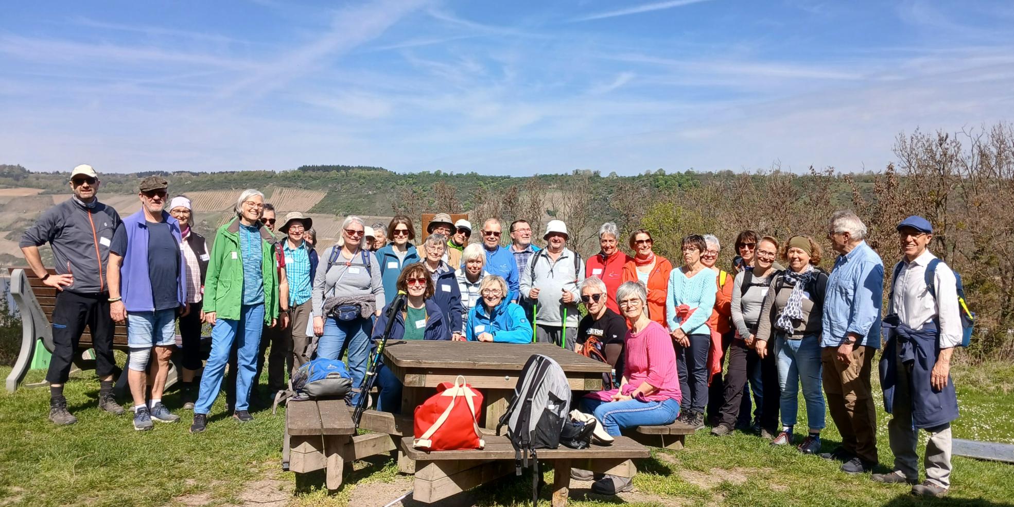 30-köpfige Pilgergruppe vor einer Bank mit strahlend blauem Himmel