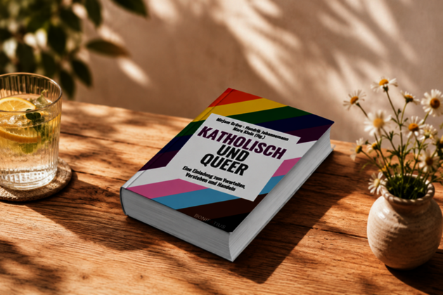 Ein Buch mit dem Titel: Katholisch und Queer liegt auf einem Tisch im Schatten