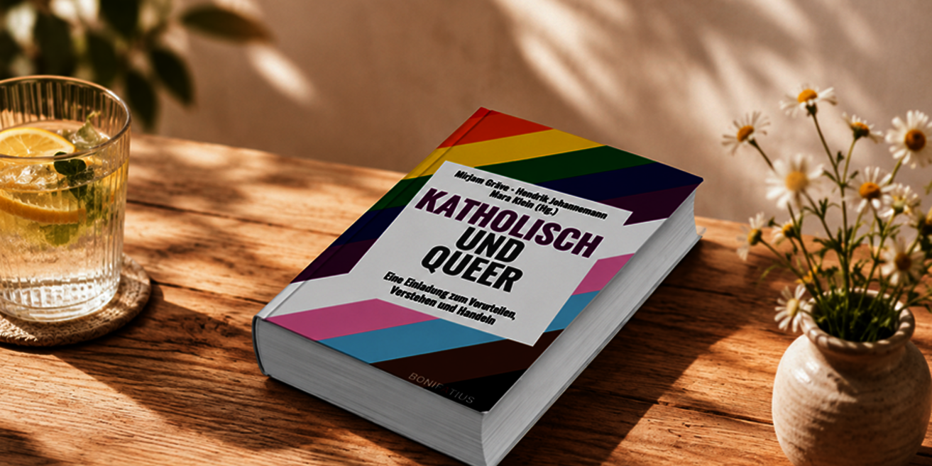 Ein Buch mit dem Titel: Katholisch und Queer liegt auf einem Tisch im Schatten