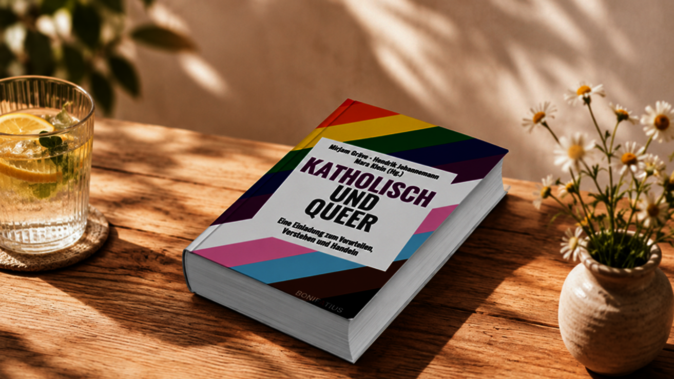 Ein Buch mit dem Titel: Katholisch und Queer liegt auf einem Tisch im Schatten
