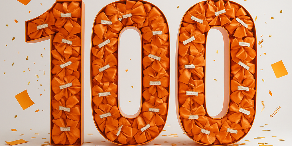 Die Zahl einhundert in Orange mit Konfetti