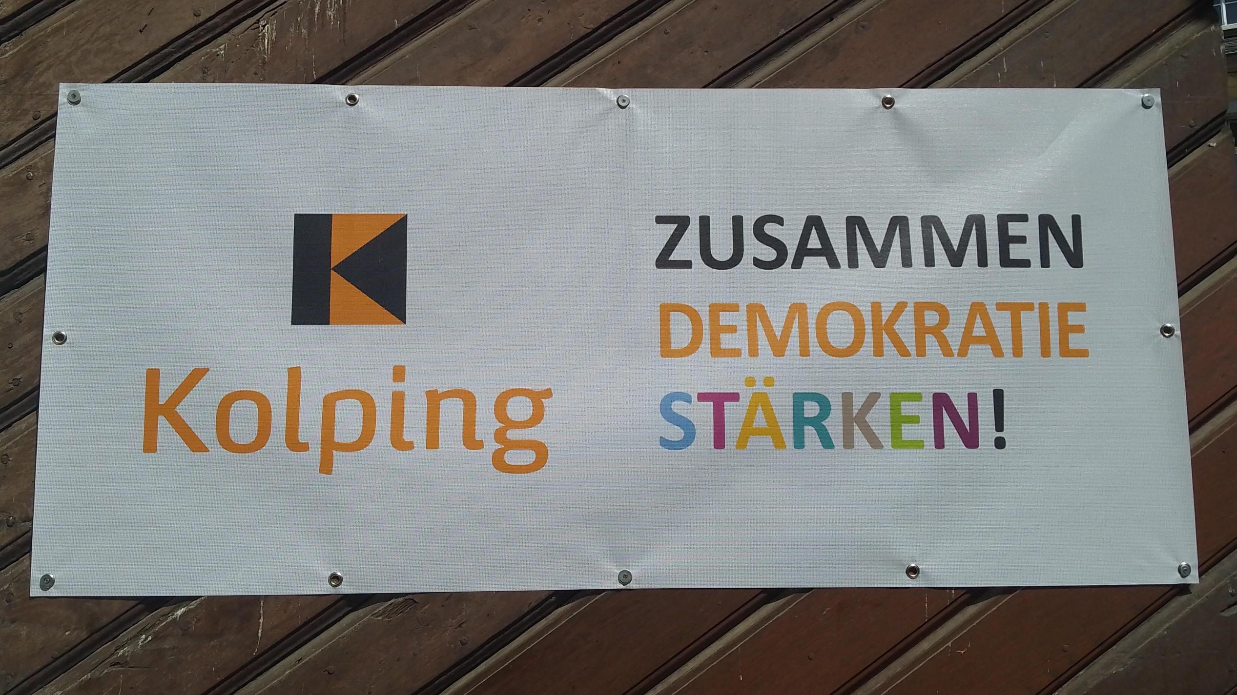 Banner mit Kolping Logo und dem Text 'zusammen Demokratie stärken'.