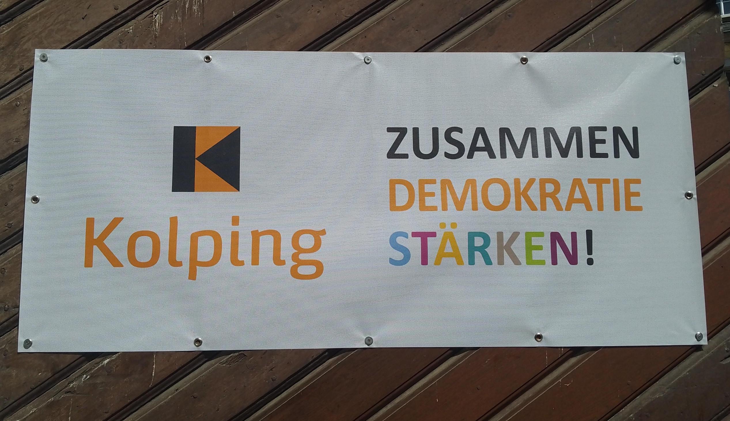 Banner mit Kolping Logo und dem Text 'zusammen Demokratie stärken'.
