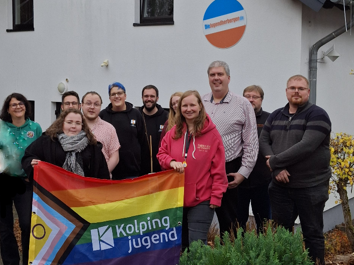 Gruppenbild vor der Jugendherberge Tholey mit Pride Banner der Kolpingjugend