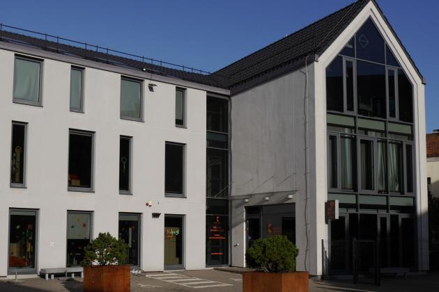 Man sieht ein modernes Haus vor strahlend blauem Himmel.