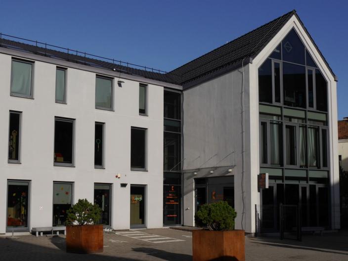 Man sieht ein modernes Haus vor strahlend blauem Himmel.
