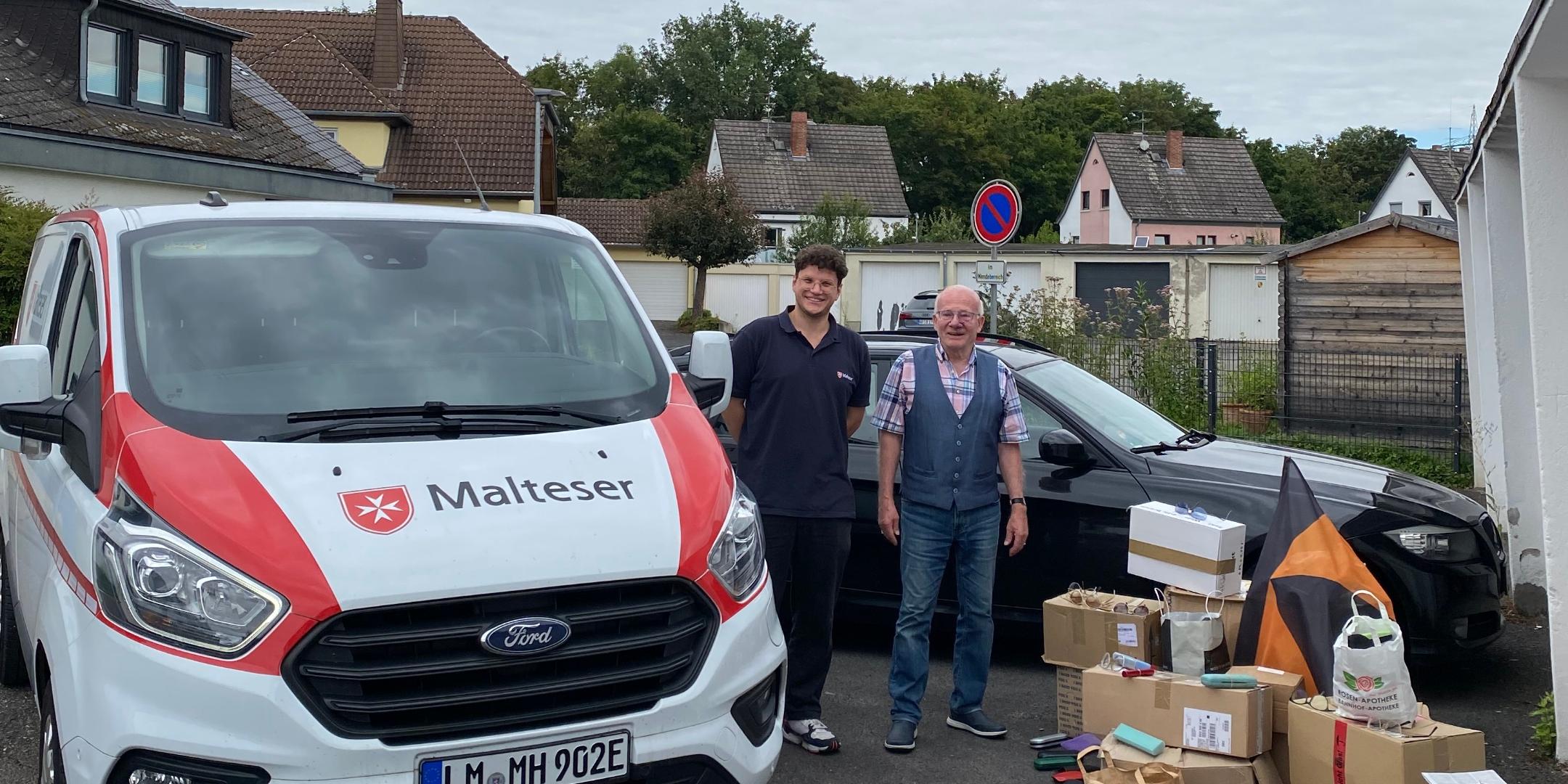 Ein Malteser Auto mit Malteser Mitarbeiter, dazu Werner Hammes und gesammelte Brillen