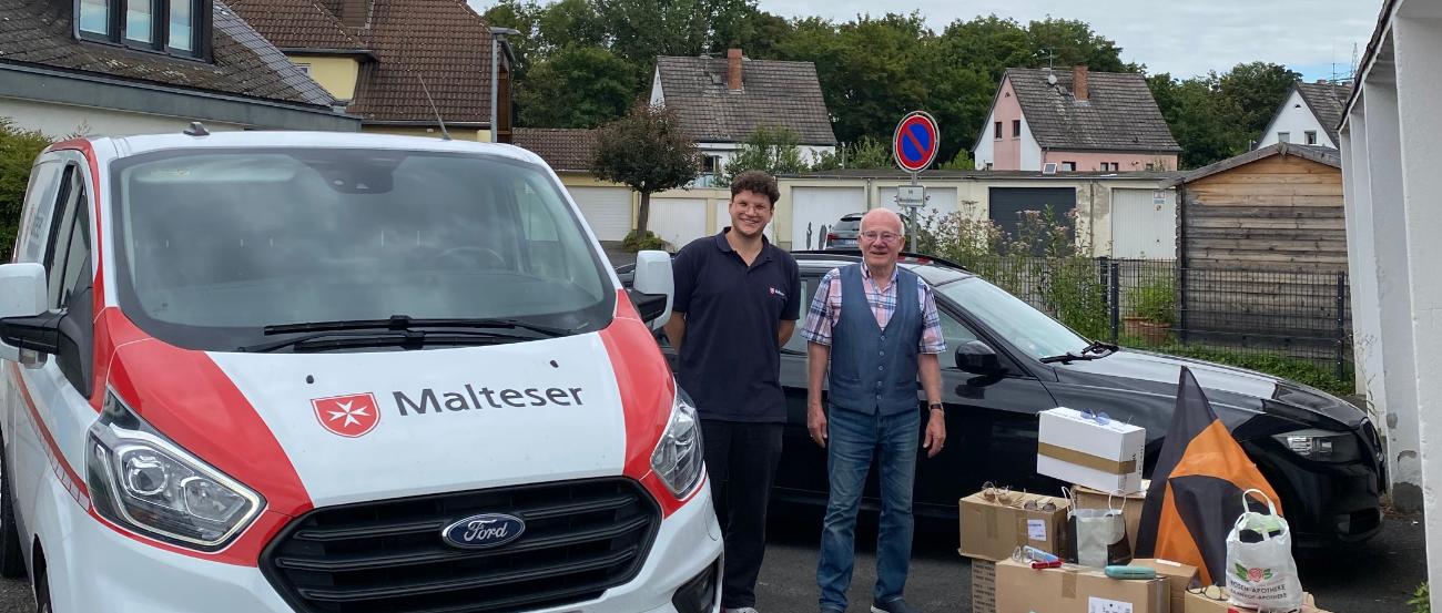 Ein Malteser Auto mit Malteser Mitarbeiter, dazu Werner Hammes und gesammelte Brillen
