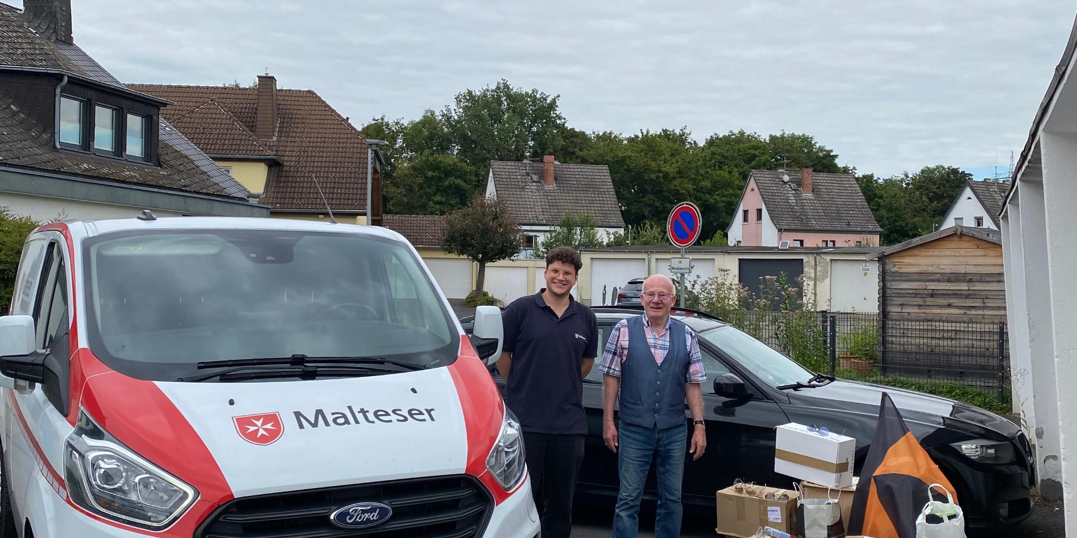 Ein Malteser Auto mit Malteser Mitarbeiter, dazu Werner Hammes und gesammelte Brillen