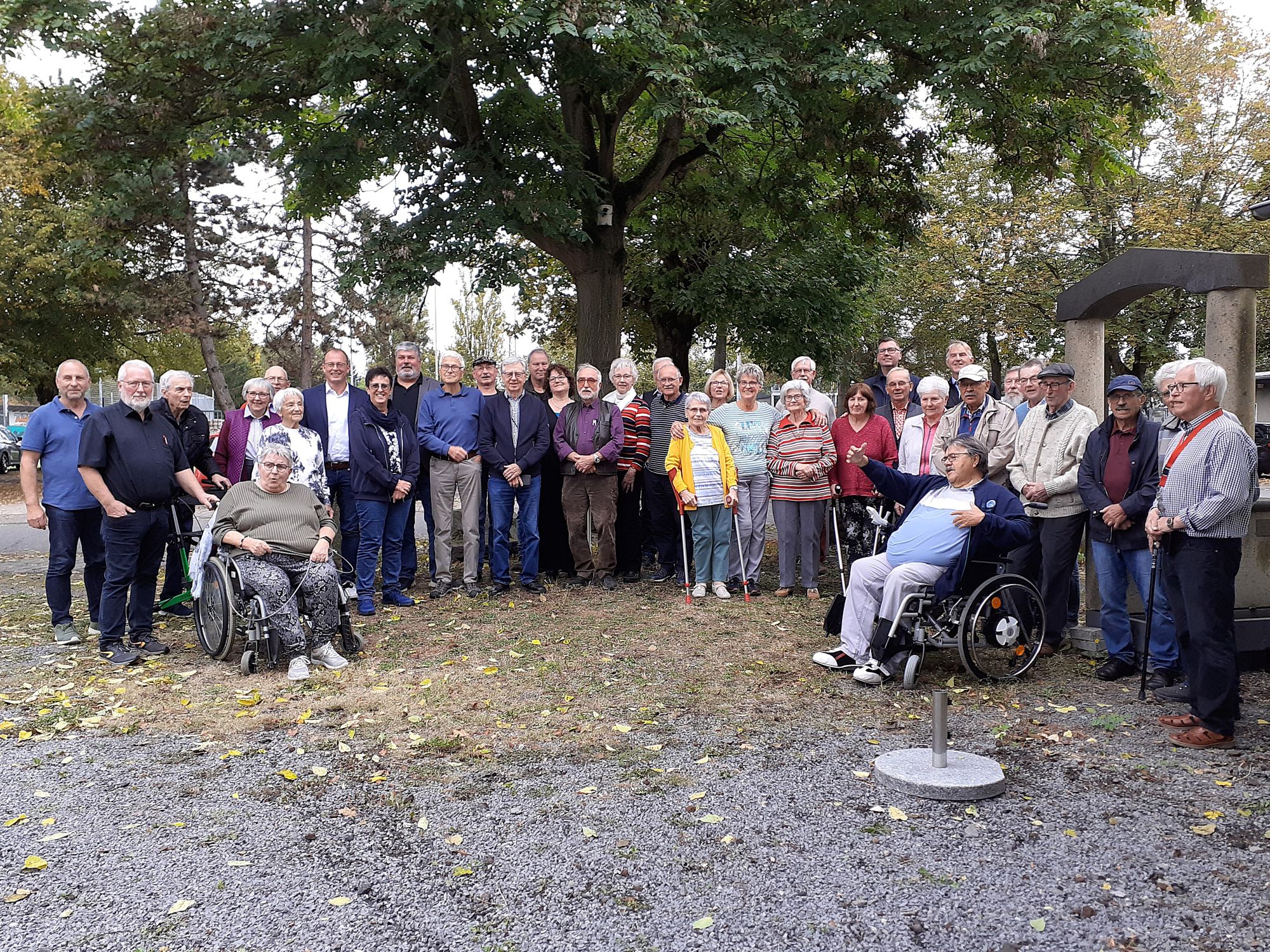 Gruppenfoto mit Senioren und Senioren, im Hintergrund sind Bäume zu sehen.
